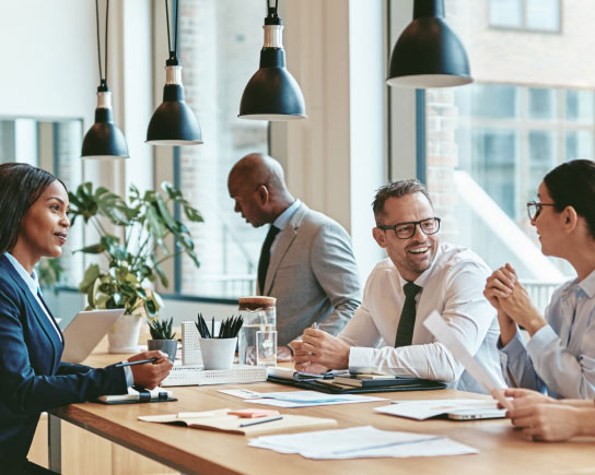 Several coworkers sitting at conference table, talking